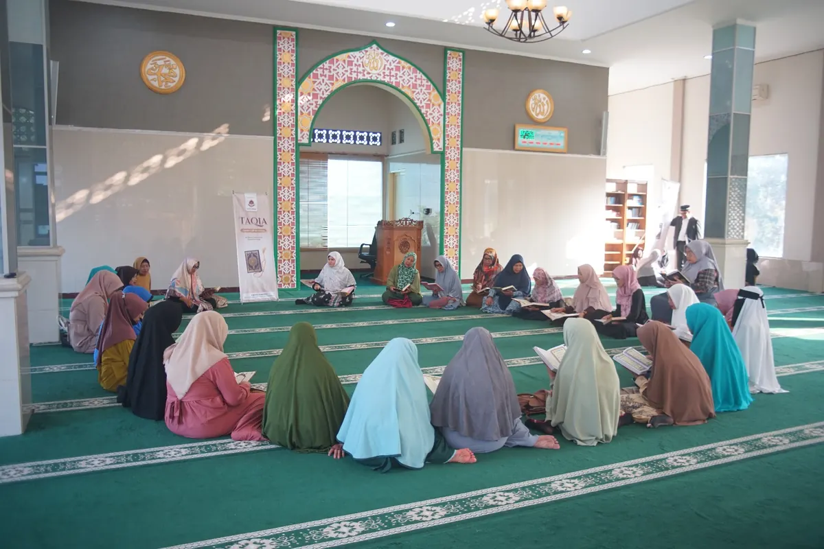 Puluhan jamaah perempuan bermukena duduk berbaris mengikuti pengajian di sebuah masjid
