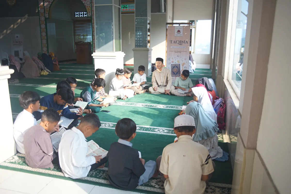 Anak-anak dan jamaah duduk berdesakan belajar Al-Qur'an di ruang terbatas